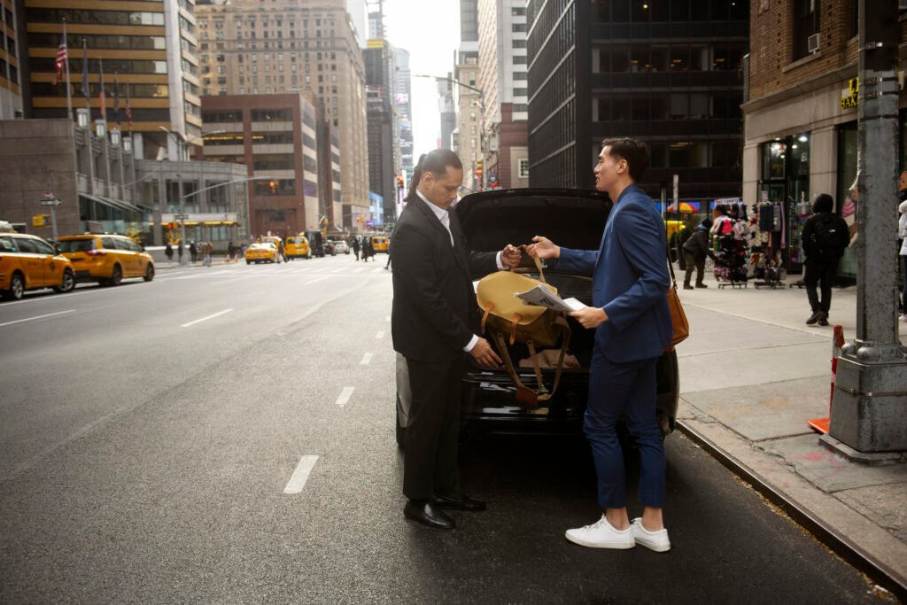 Luxury taxi service Paris – chauffeur helping client with luggage in the trunk